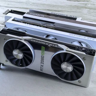Three NVIDIA GeForce RTX graphics cards stacked on a surface, showcasing their sleek design and branding details.