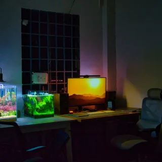 a desk with a computer and a fish tank