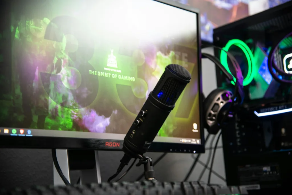 black microphone beside black flat screen computer monitor